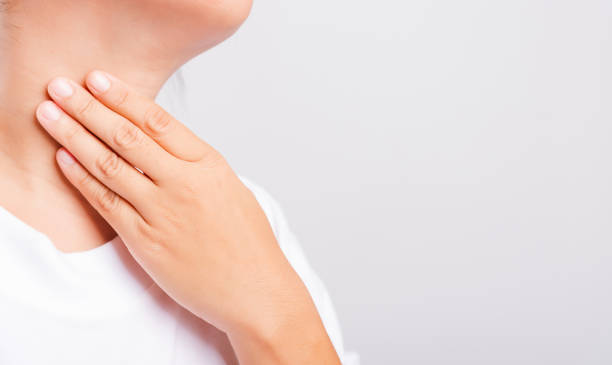 istock Asian beautiful woman Sore Throat or thyroid gland problem her useing Hand Touching Ill Neck on white background 1208064819