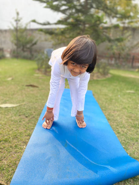 Little Boy in India does Yoga Exercises. This Very Young India Child Demonstrates Real Talent as he Practices Yoga Poses Outdoors.  It is a Bright Sunny Day and this Boy is clearly Enjoying  himself.  Although Still Learning, he has Mastered all of the Basic Yoga Poses and Stretches, and  He is Simply Delighted to Show Us what he Knows! indian boy barefoot stock pictures, royalty-free photos & images