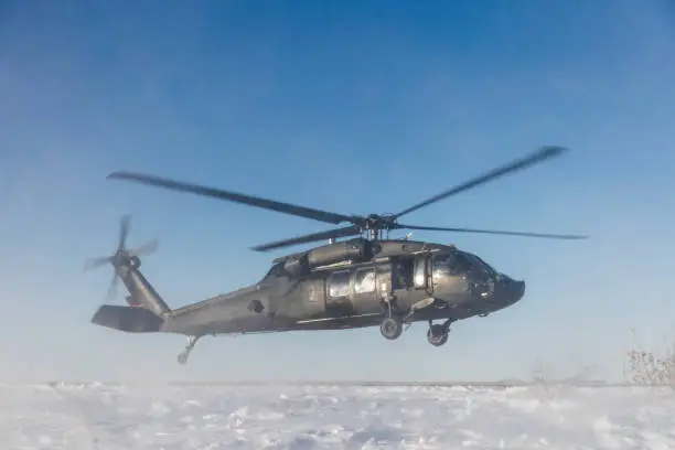 UH-60 Blackhawk Military Helicopter landing on snow