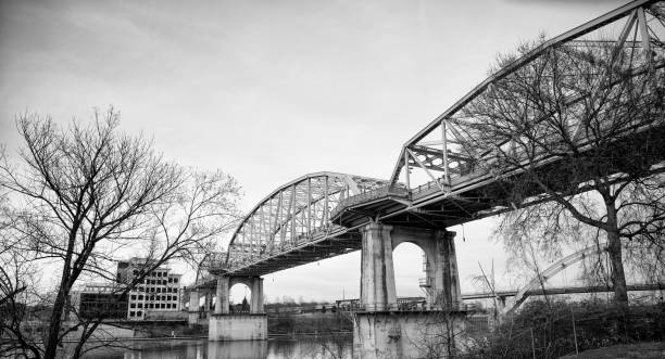 Bridge across water in USA Black and White image of traditional bridge across water over sky in Nashville Tennessee, USA nashville tennessee bridge stock pictures, royalty-free photos & images
