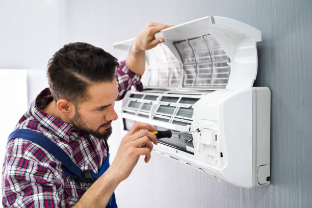 Repairer Repairing Air Conditioner Happy Male Technician Repairing Air Conditioner With Screwdriver air conditioner photos stock pictures, royalty-free photos & images