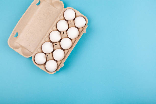 istock Egg Chicken eggs. Top view of an open gray box with white eggs. Isolated on a blue background. The concept of a healthy lifestyle, getting pure protein. Proper Breakfast. Preparing for Easter 1208085228