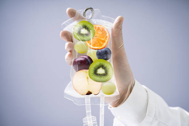 Doctor Holding Saline Bag With Fruit Slices Inside In Hospital Male Doctor Holding Saline Bag With Fruit Slices Inside In Hospital iv drip photos stock pictures, royalty-free photos & images