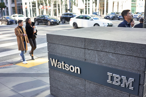 San Francisco, CA, USA - Feb 8, 2020: People walking past the IBM Watson sign outside its San Francisco office. Watson is a question-answering computer system capable of answering questions posed in natural language.