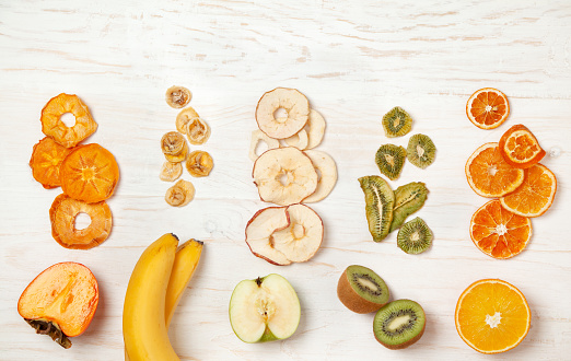 wooden background with fresh fruits and fruit chips. view from above.