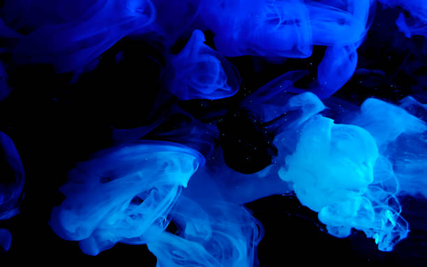 istock Blue watercolor ink in water on a black background. Colored space background. 1208090484