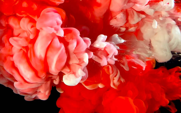 istock Red and white watercolor ink in water on a black background. Colored space background. 1208090508