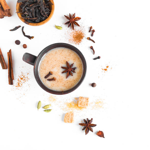 Indian Masala Chai Tea Masala Chai Tea in ceramic cup with ingredients. Traditional indian spicy black tea with milk isolated on white background, top view, copy space. chai stock pictures, royalty-free photos & images