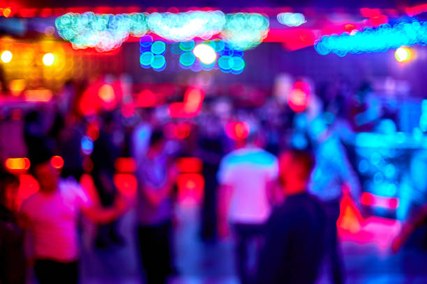 la gente baila cantar divertirse y relajarse en un club nocturno de fondo borroso. destellos de luz hermosas luces borrosas en la pista de baile relajarse por la noche en el club - party dj nightclub party nightlife fotografías e imágenes de stock