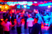 People dance sing have fun and relax in a nightclub blurred background. Flashes of light Beautiful blurry lights on the dance floor relax at night in the club