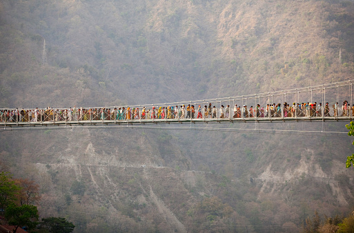 Large group of Hindu pilgrims passing the bridge during Kumbh Mela, Rishikesh India