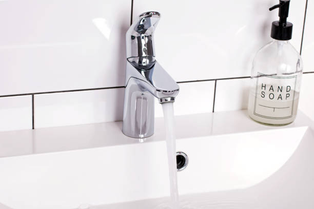 istock Bathroom sink with soap and running water from tap 1208101660