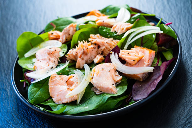 istock Vegetable salad with roasted salmon on wooden background 1208104231