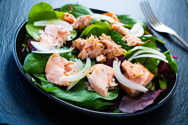 istock Vegetable salad with roasted salmon on wooden background 1208104286