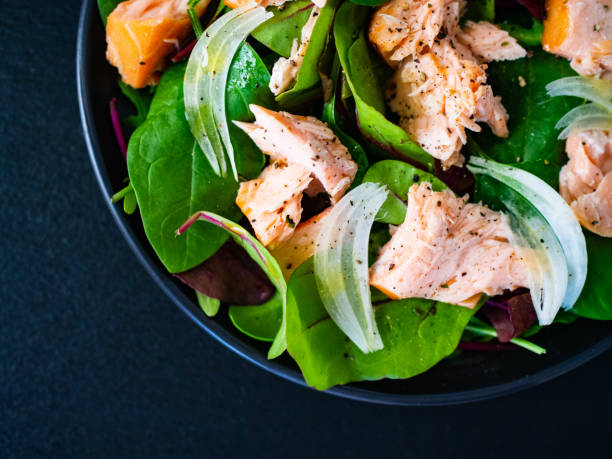 istock Vegetable salad with roasted salmon on wooden background 1208104559