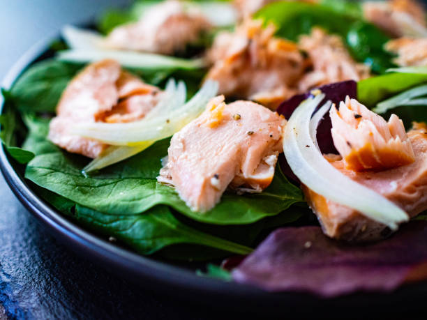 istock Vegetable salad with roasted salmon on wooden background 1208104710