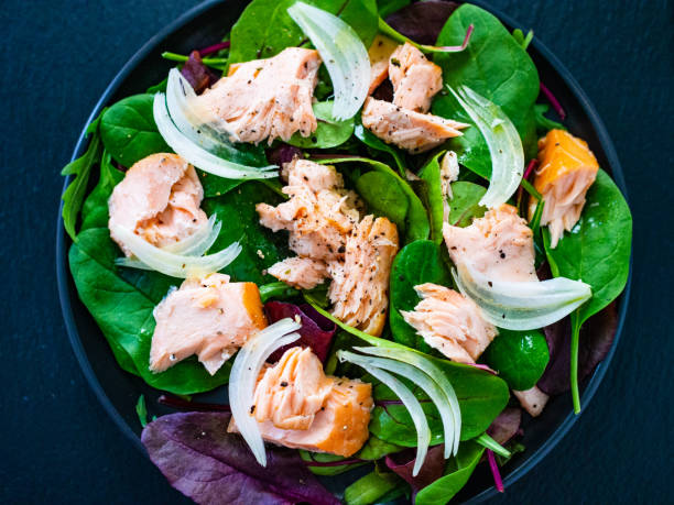 istock Vegetable salad with roasted salmon on wooden background 1208104768