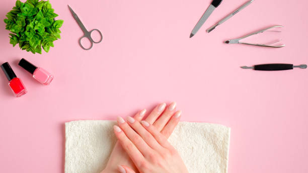istock Female hands applying manicure in nail salon.Top view nail studio workspace with manicure tools and nail polish bottles. Beauty treatment concept 1208104821