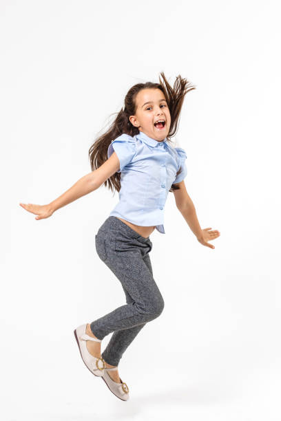 istock little girl jumps on a white background 1208106106