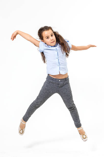 istock little girl jumps on a white background 1208106237