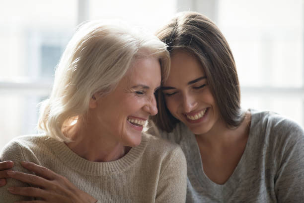 istock Attractive grown up daughter and middle aged mother laughing 1208113571
