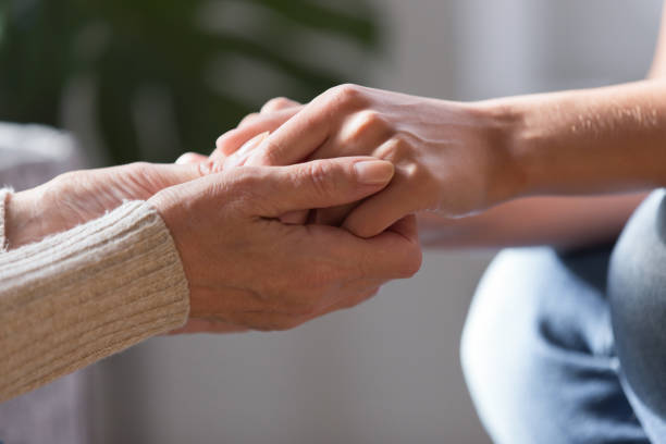 istock Two females holding hands close up view image 1208113591