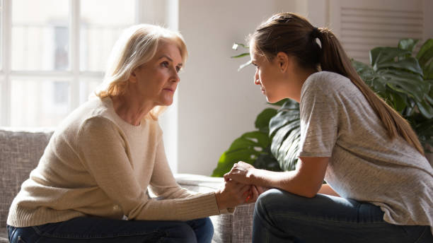 Different generations women talking holding hands giving psychological support Grown up daughter holding hands of middle aged mother relatives female sitting look at each other having heart-to-heart talk, understanding support care and love of diverse generations women concept emotional support stock pictures, royalty-free photos & images