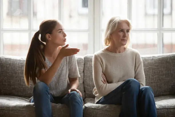 Photo of Annoyed grown up daughter expressing complaints to elderly mother