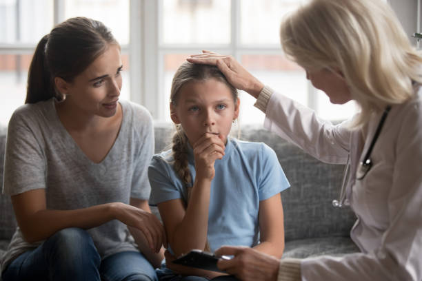 pediatra lekarz głaszcząc głowę małej chorej dziewczynki podczas wizyty - doctor old male family zdjęcia i obrazy z banku zdjęć