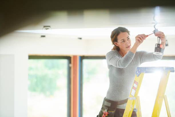 female electrician installing downlights female electrician installing downlights woman wearing tool belt stock pictures, royalty-free photos & images