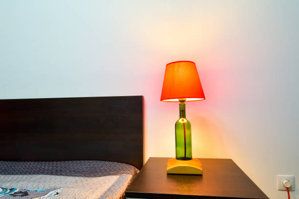 istock Lamp on a night table next to a bed 1208116250