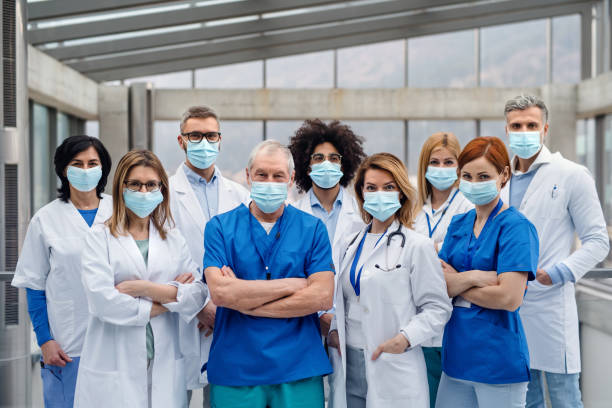 grupo de médicos con máscaras faciales mirando la cámara, concepto de virus corona. - coronavirus fotos fotografías e imágenes de stock
