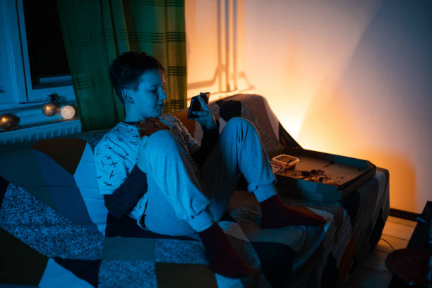 istock Boy in pajamas eating pizza and using mobile phone 1208117765