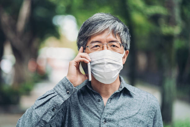 istock Asian ethnicity man with protective mask and cell phone 1208119191