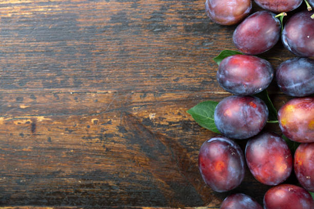 istock Ripe plums on a wooden surface. Fresh fruits. 1208121308