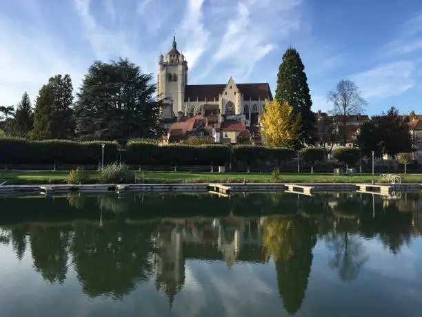 Photo of The Notre-Dame de Dole church and the old town seen from the canal port in Dole, France