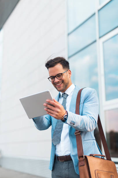 istock Businessman standing on the street and using tablet. 1208124432