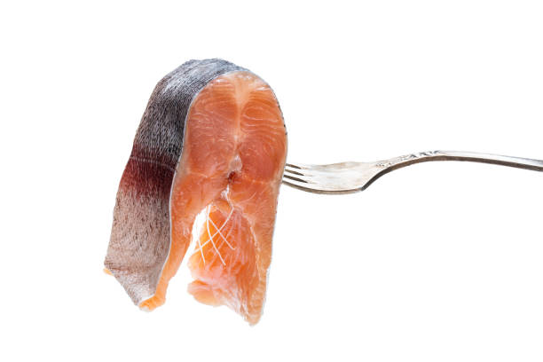 istock Salted slice of rainbow trout on a fork isolated on white 1208125207