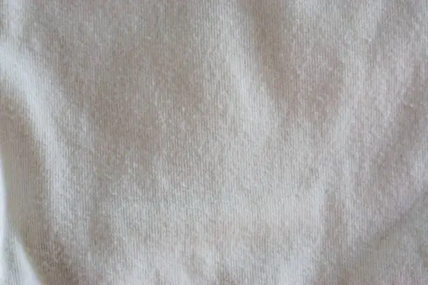 Photo of macro closeup of a pure white clean cotton fabric, popular material for clothing