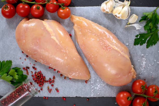 raw chicken breast with red pepper, garlic, parsley and cherry tomatoes. - garlic chicken breast raw chicken imagens e fotografias de stock