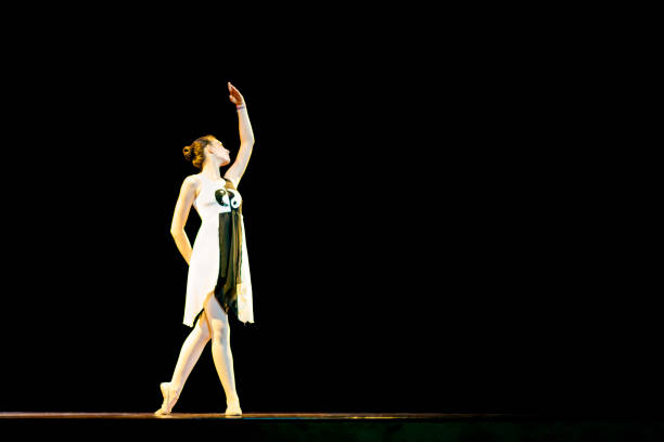 istock Young girl dancing ballet on a black stage 1208134360