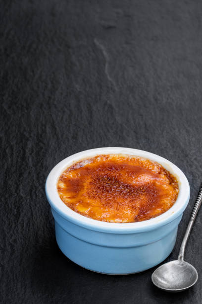 검은 돌 배경에 푸른 도자기 냄비에 크림 브릴리 - custard creme brulee french cuisine crema catalana 뉴스 사진 이미지