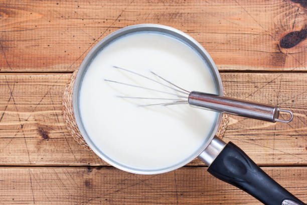 istock Step-by-step preparation of stuffed cannelloni with bechamel sauce, step 3 - preparation of bechamel sauce, top view, horizontal 1208138650