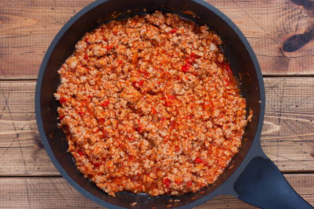 istock Step-by-step preparation of stuffed cannelloni with bechamel sauce, step 4 - preparation of bolognese sauce, top view, horizontal 1208138674