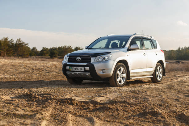 toyota rav4 2006 colore grigio tra la sabbia vicino alla foresta, open space al tramonto - dirtroad foto e immagini stock