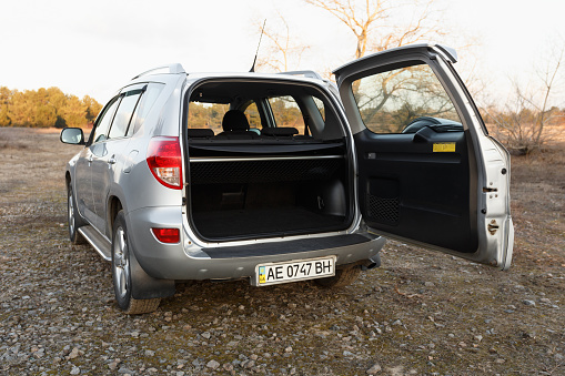 Dnipro, Ukraine - february 19, 2020: Toyota RAV4 2006 gray color with open trunk near the forest, open space in twilight