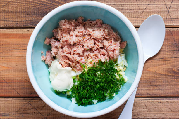 istock Step-by-step salad preparation with canned tuna and corn, step 7 - adding mayonnaise to the salad, top view, horizontal 1208140843