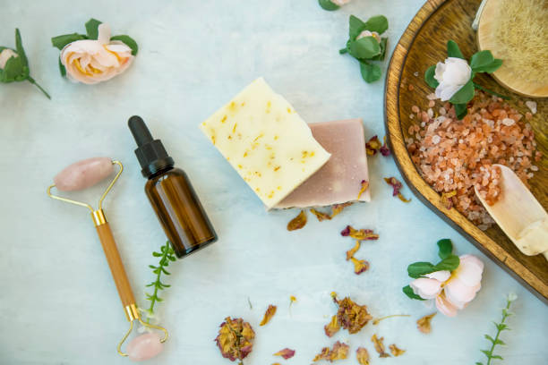 istock Spa still life setting with natural soap, rose quartz face roller, rose oil bottle and bath salt , top view 1208140931