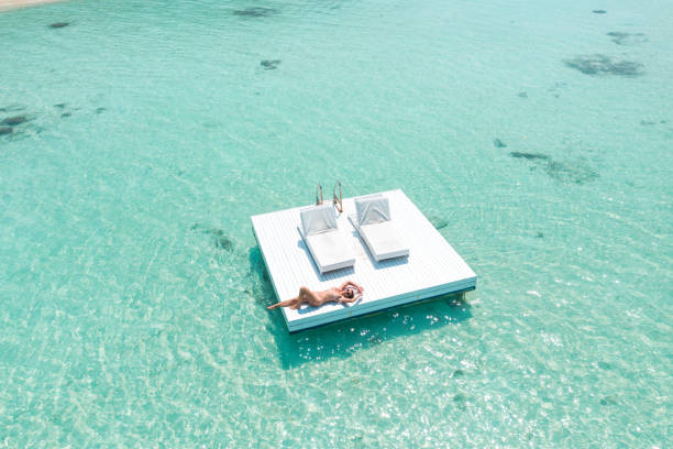 istock Attractive woman relaxing on floating platform in ocean 1208144723