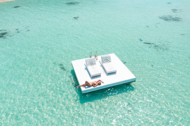 istock Attractive woman relaxing on floating platform in ocean 1208144836